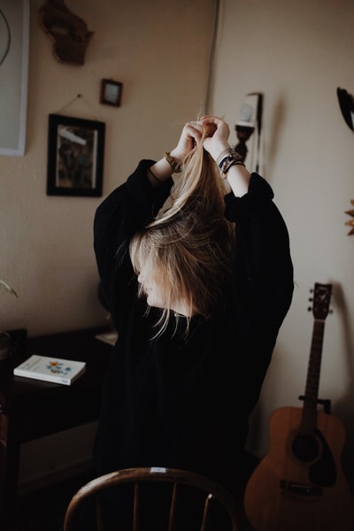 A woman dressed in a black sweater with hair
